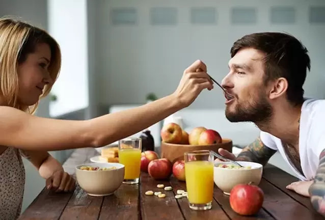 žena hrani muškarca orašastim plodovima kako bi povećala potenciju